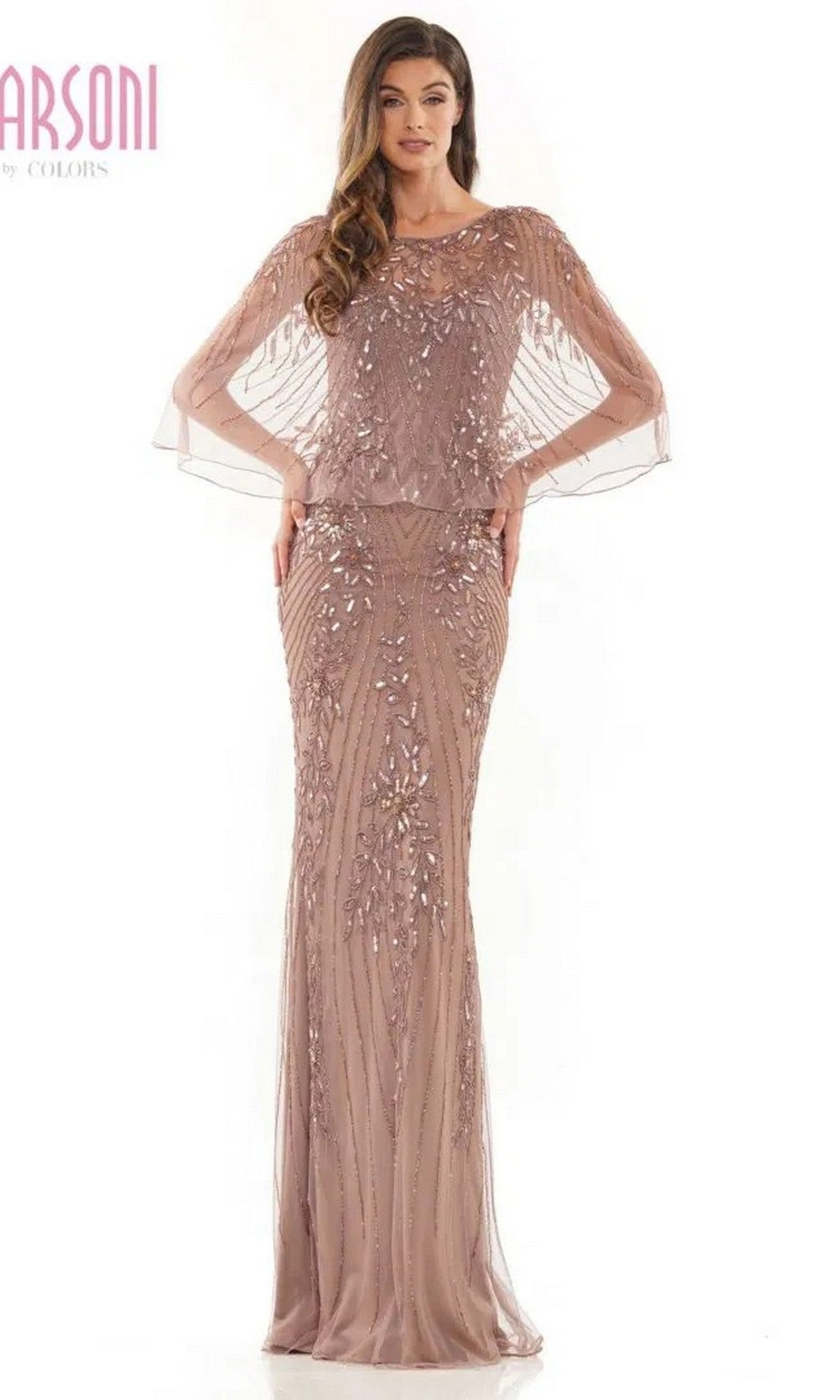 A woman stands against a white background wearing the Marsoni MV1201 long formal dress in dark taupe, featuring floor-length design with sheer, beaded embellishments on the sleeves and skirt.